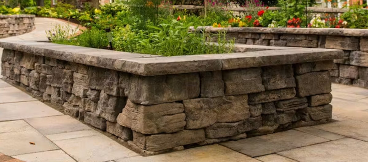 Rosetta Belvedere raised planter wall with stone caps on a flagstone patio