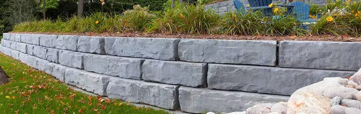 Rosetta Grand Ledge large-format gray stone retaining wall along a lawn