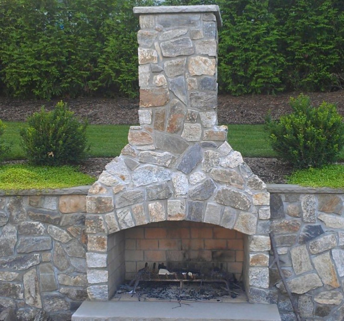 Outdoor fireplace and seat wall faced in R Stone natural thinstone
