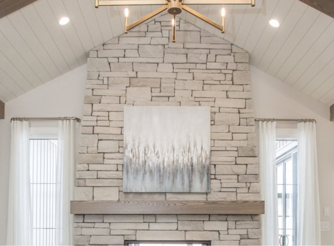 Floor-to-ceiling Cultured Stone fireplace wall under a vaulted ceiling