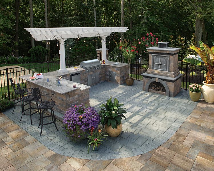 Cambridge pavingstone patio with outdoor kitchen, pergola and pizza oven