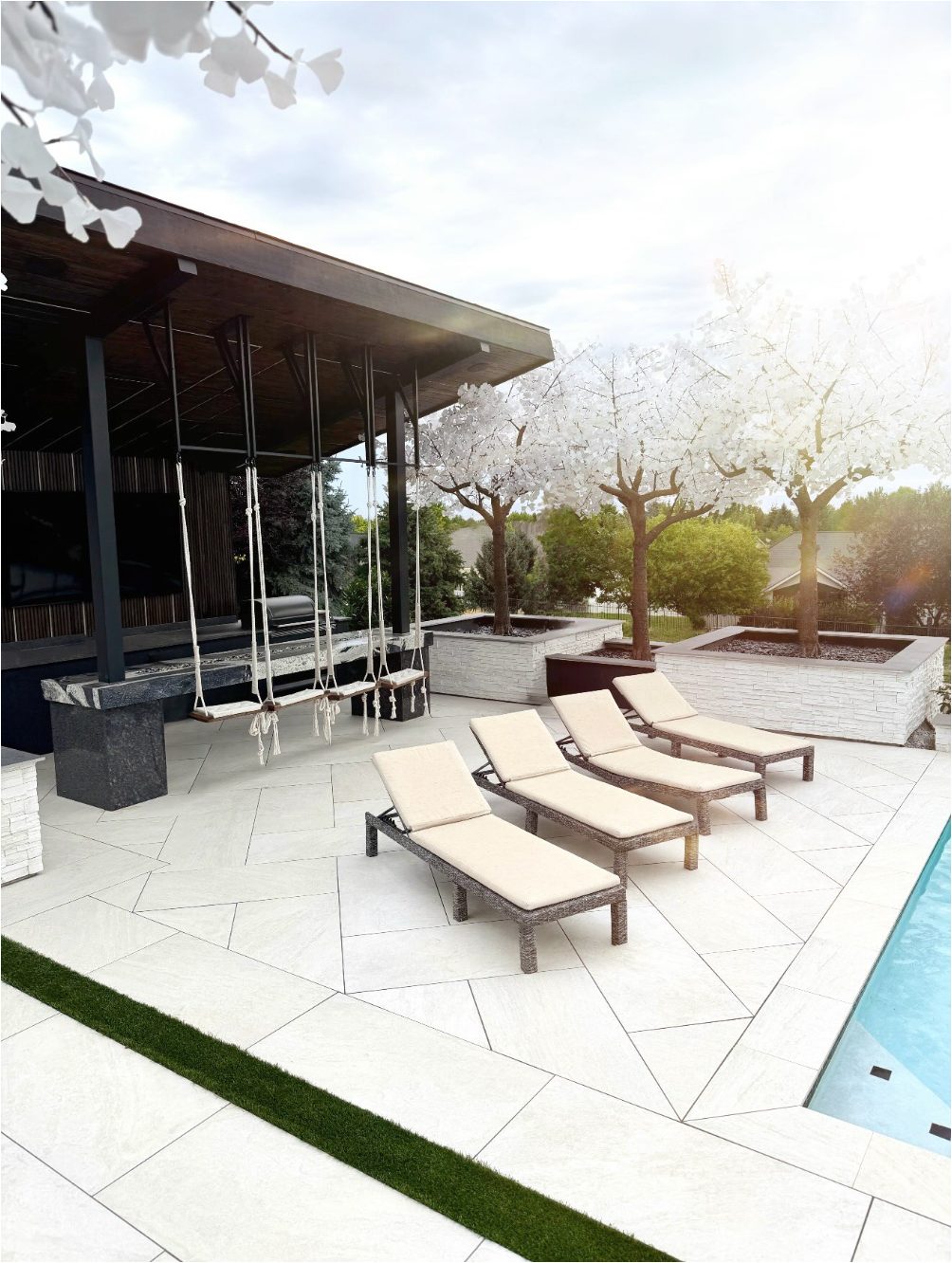 MSI porcelain paver pool deck with lounge chairs and outdoor kitchen