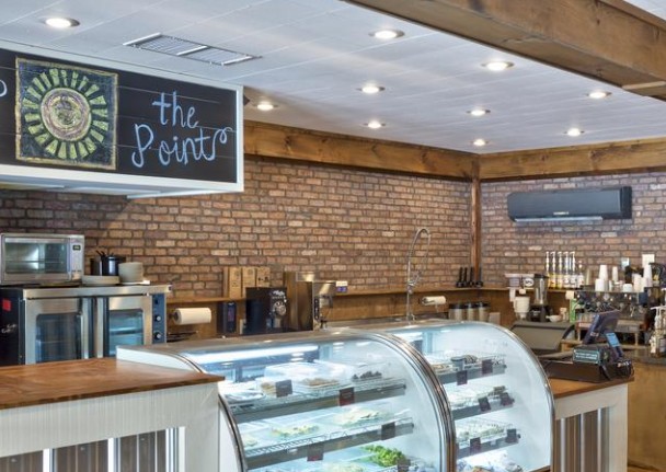 Cafe interior with thin brick walls behind the deli case and coffee bar