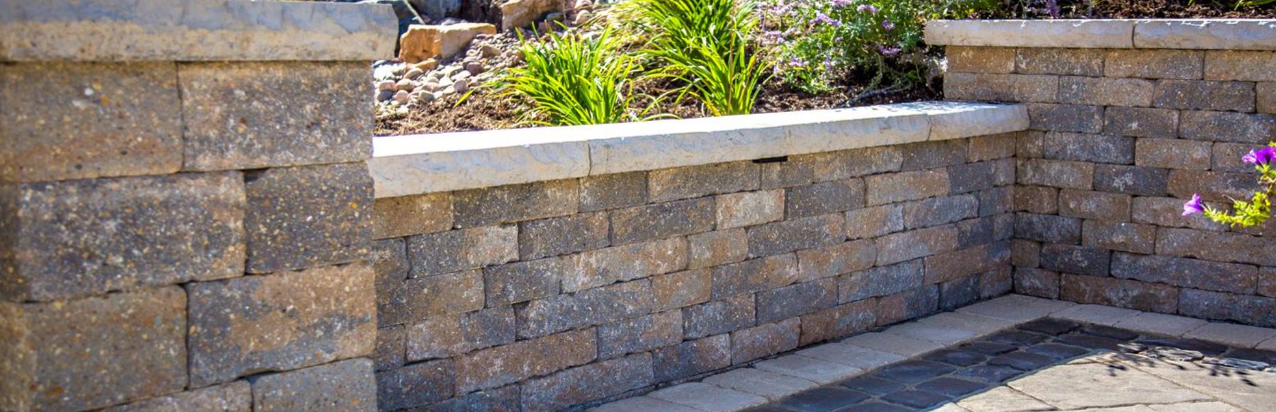 Unilock retaining wall with planter bed and stone cap