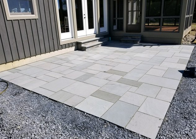 Thermal blue bluestone pattern patio behind a house