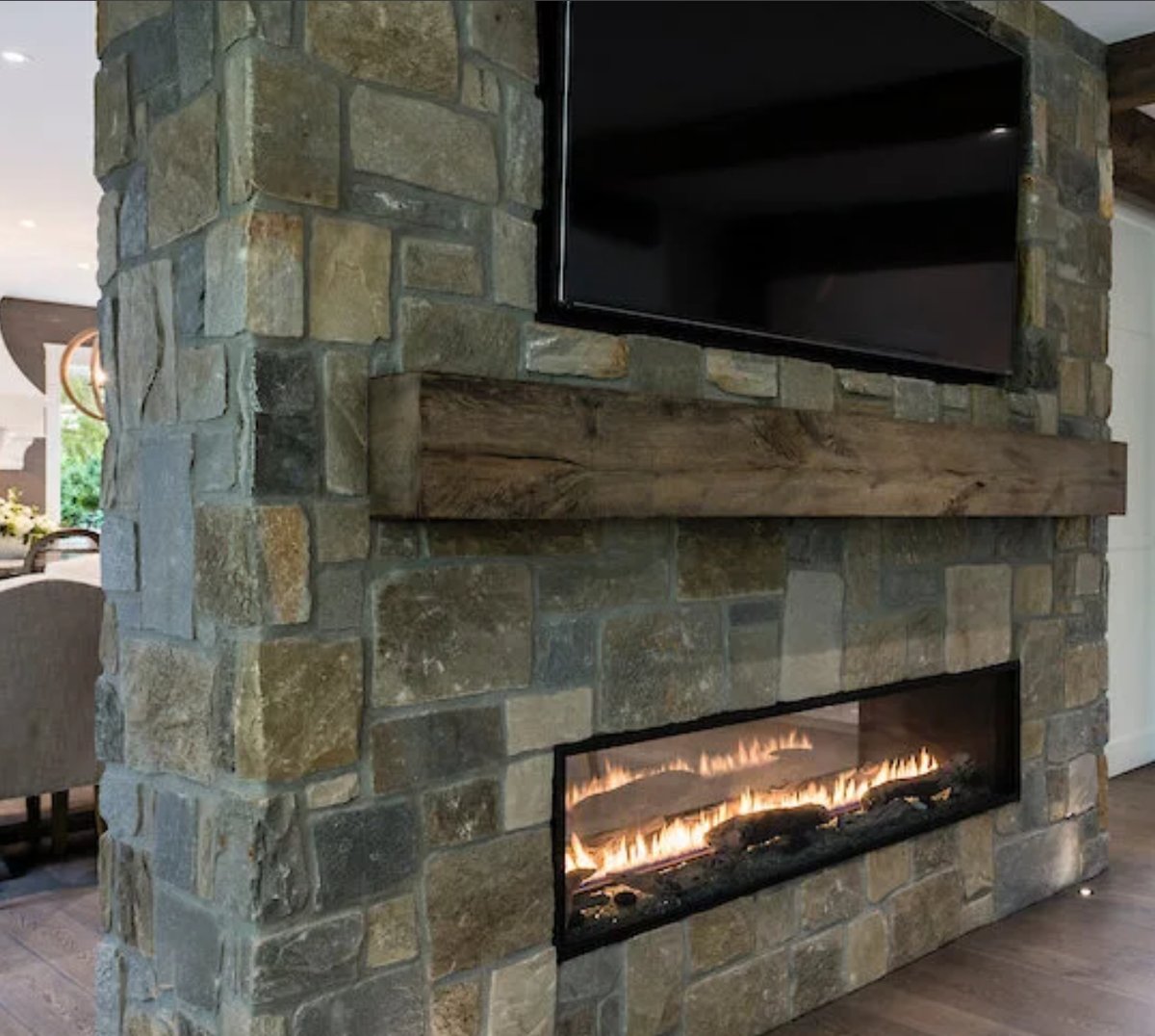 Pangaea natural stone see-through fireplace with reclaimed wood mantel