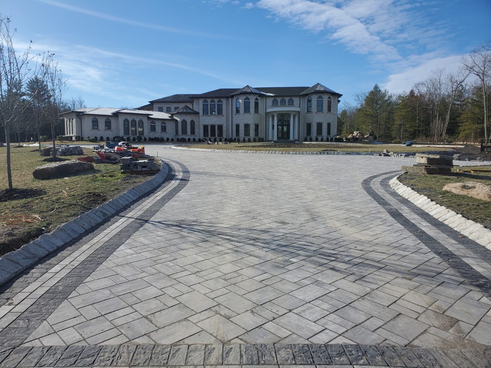 Circular paver driveway in front of a large estate home