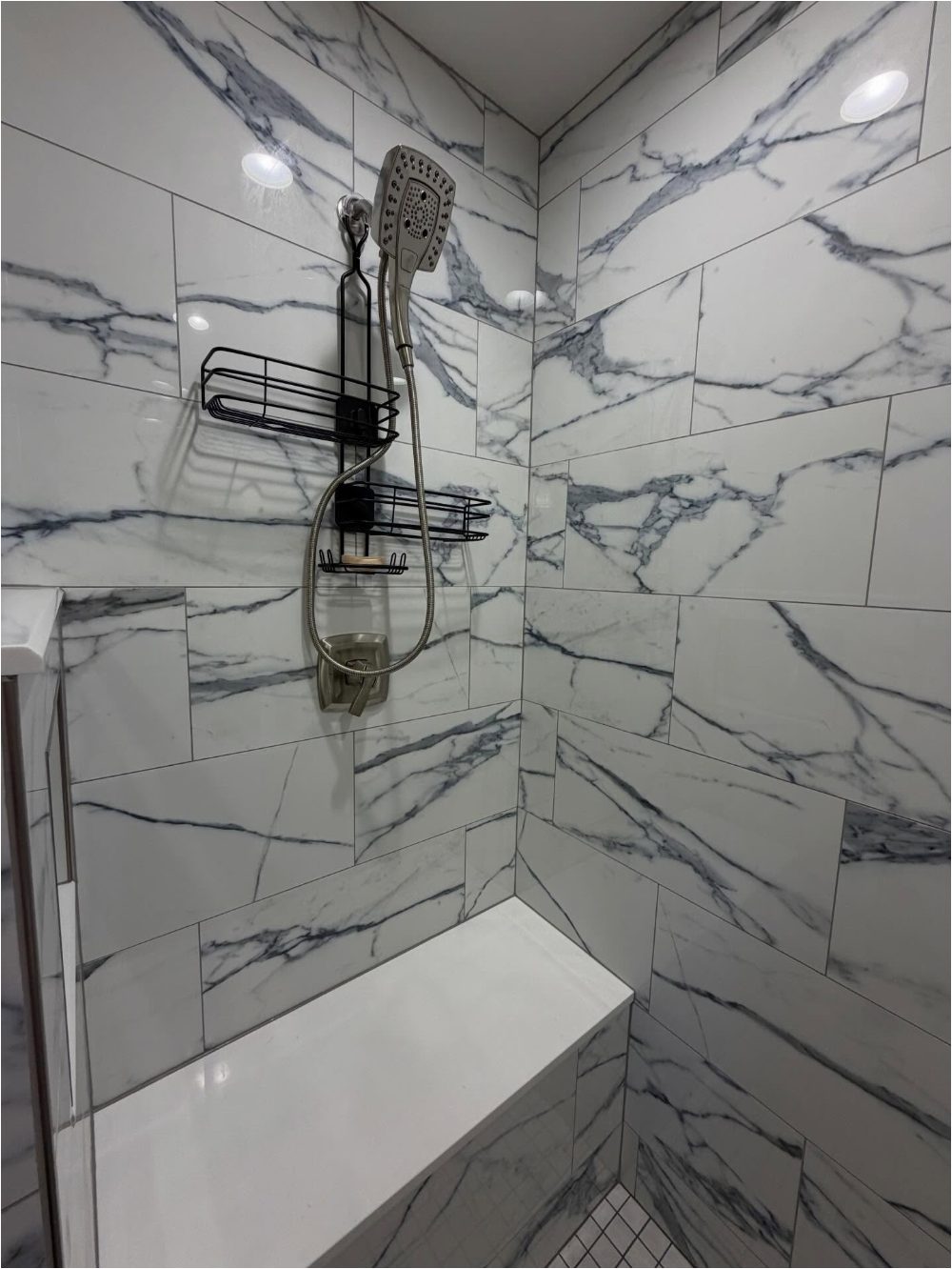 Marble-look porcelain tile shower surround with built-in bench