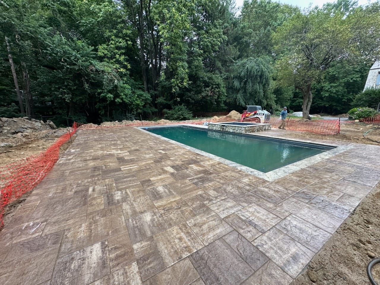 Paver pool deck surrounding an in-ground pool