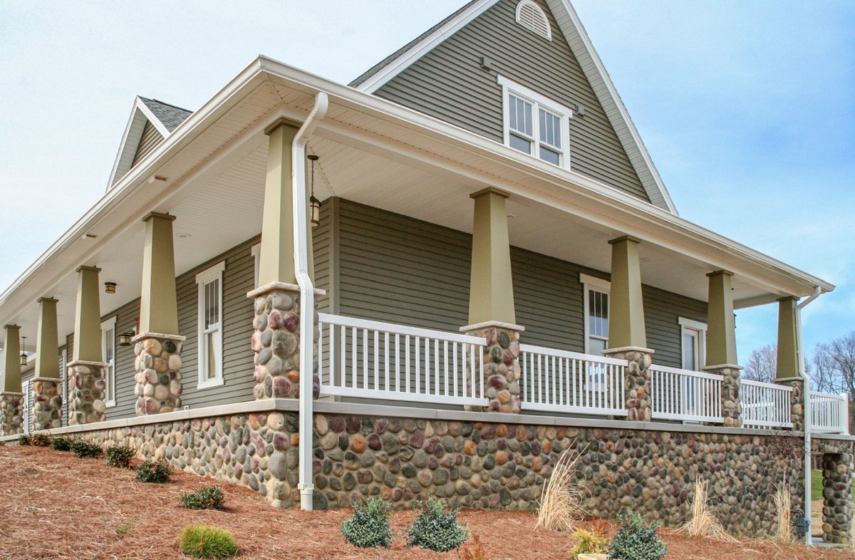 Wraparound porch with ProVia river rock column bases and foundation wall