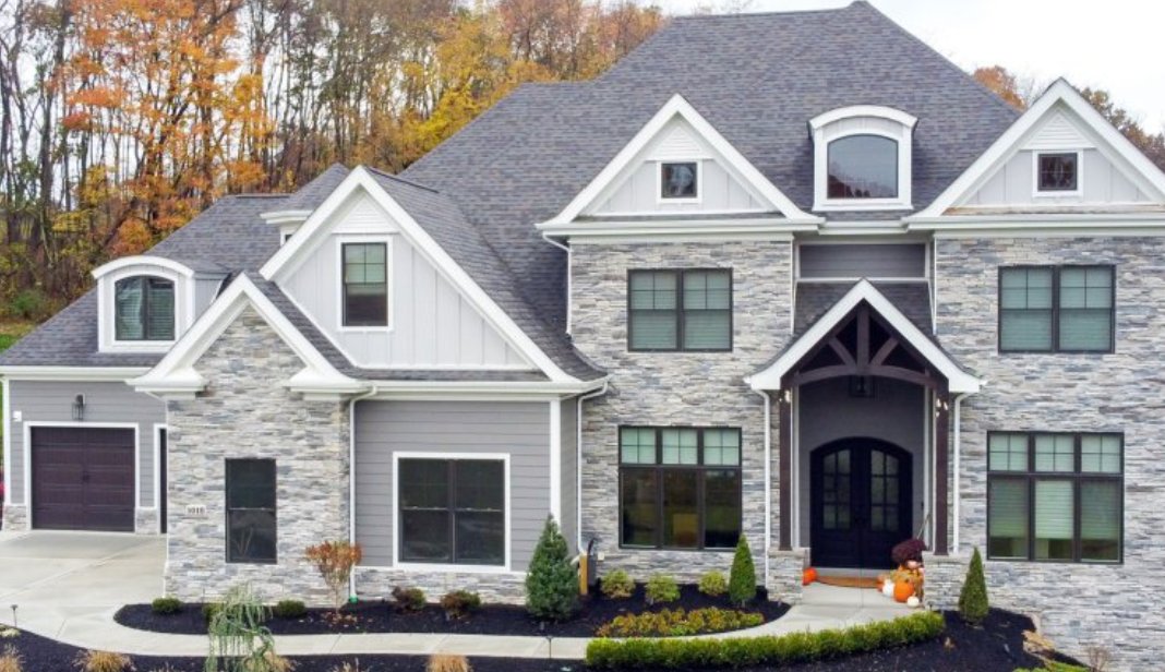 Two-story home with Cultured Stone ledgestone facade and arched entry