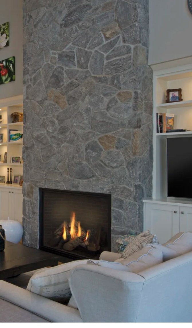 Floor-to-ceiling Pangaea fieldstone fireplace in a living room