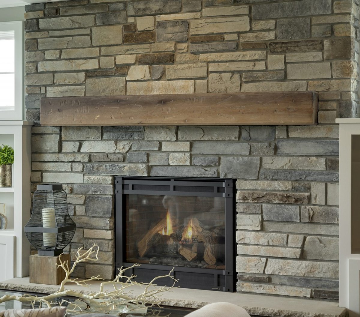 Cultured Stone ledgestone fireplace with a rustic wood mantel