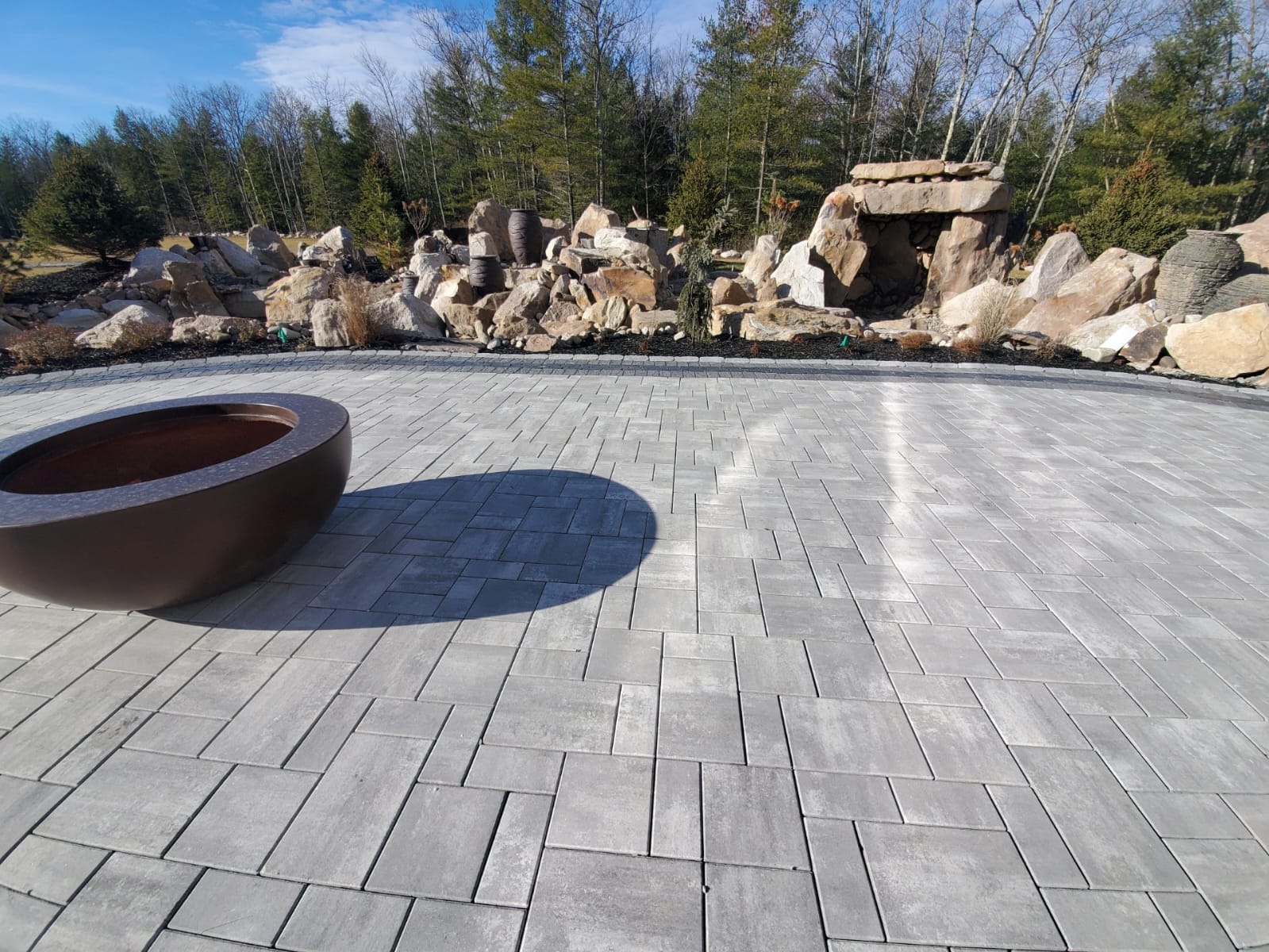 Paver patio with fire bowl and natural stone rock feature
