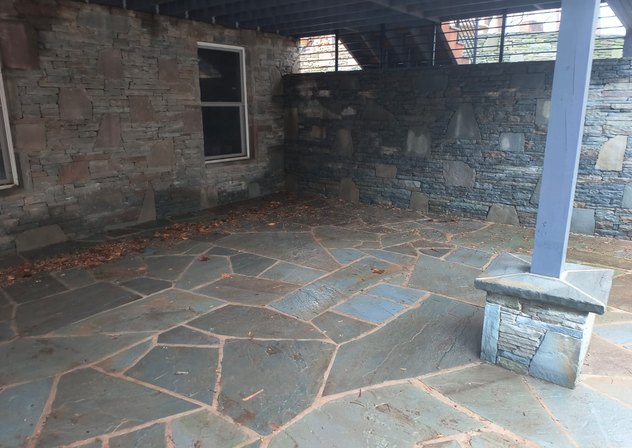 Covered bluestone flagstone patio with stacked stone walls and column base