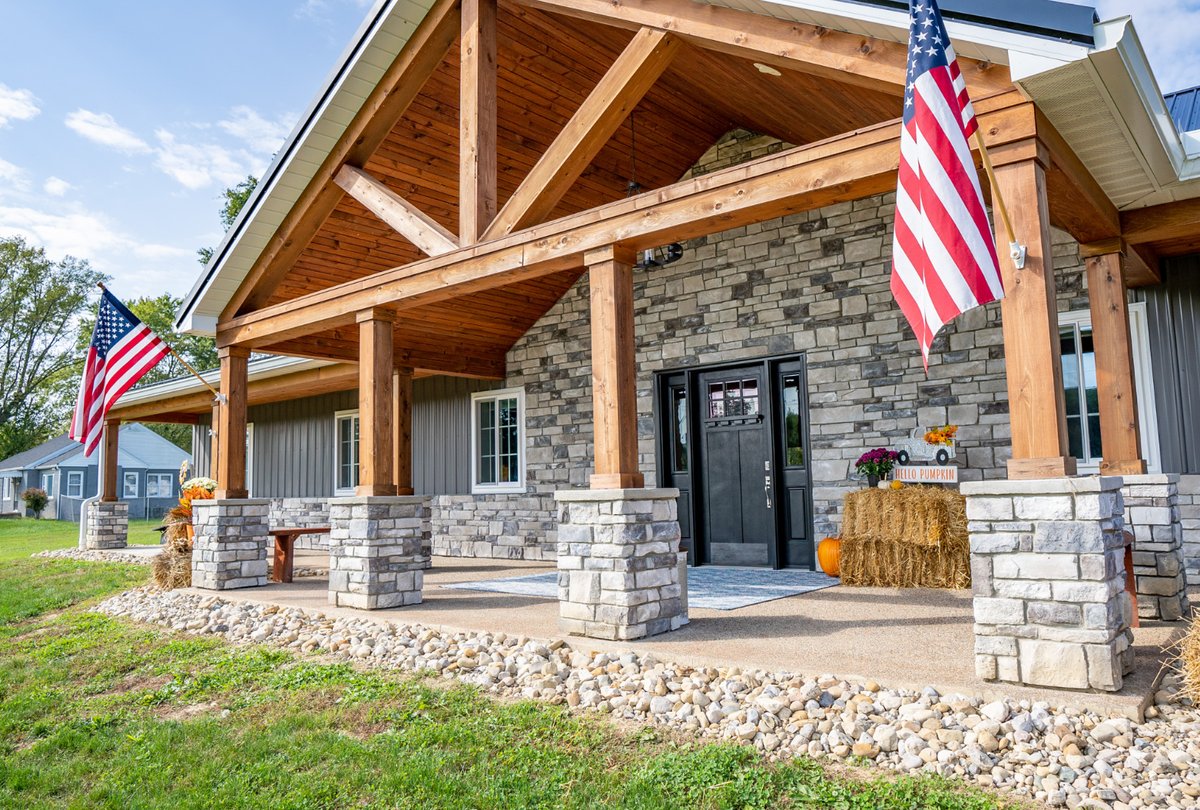 Timber-frame front porch with light gray ProVia stone columns and entry wall