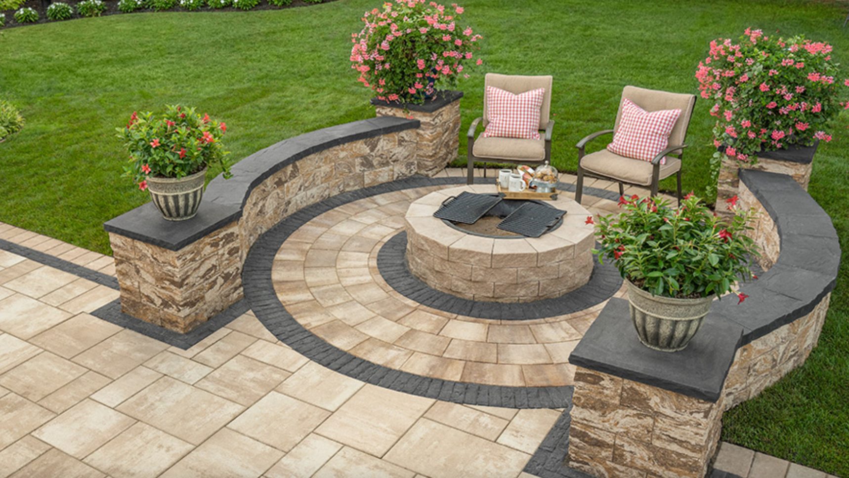 Curved Cambridge seat wall with pillars around a paver patio and fire pit