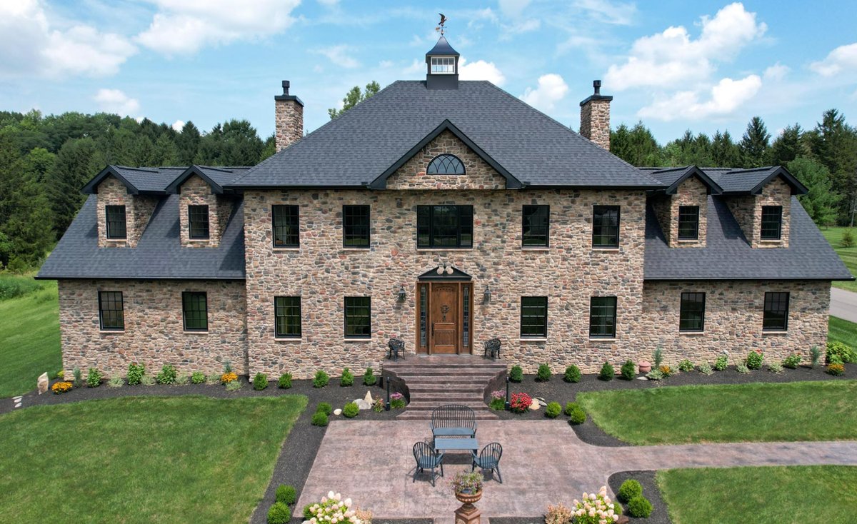 Estate home fully clad in ProVia fieldstone with stone chimneys and dormers