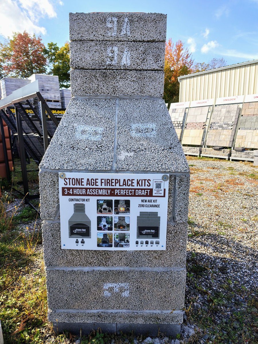 Stone Age fireplace kit display with sizing sign in the yard