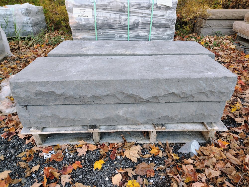 Cambridge 48 inch cast stone steps in Bluestone stacked on a pallet in the yard