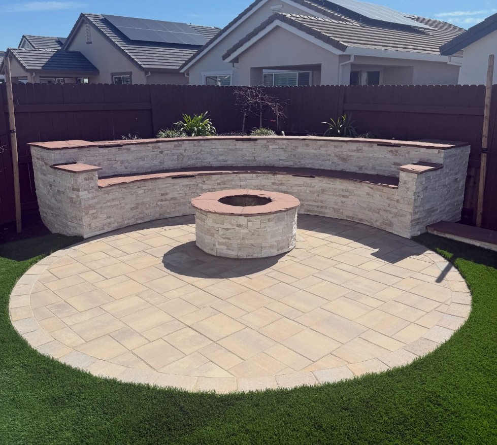 Curved stacked stone seat wall and fire pit on a circular paver patio