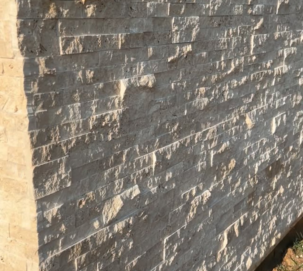 Close-up of a split-face travertine stacked stone wall
