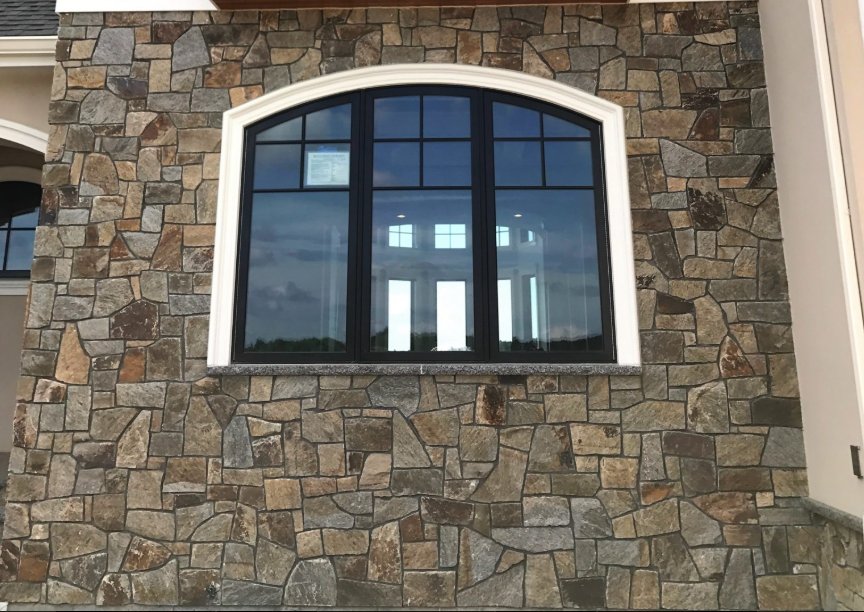 Home exterior wall in R Stone mosaic natural thinstone around an arched window