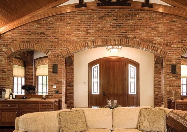 Great room with a thin brick wall and arched openings around the front door