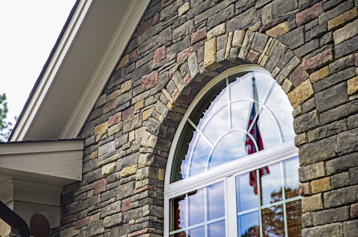 ProVia stone gable wall with a stone arch around a half-round window