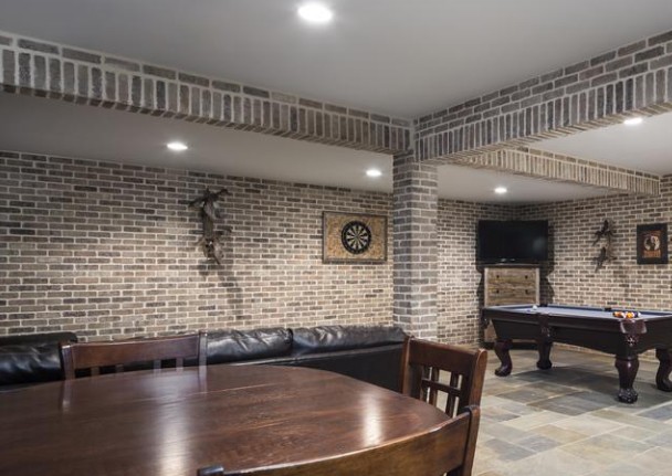 Finished basement game room with thin brick walls, columns and arches