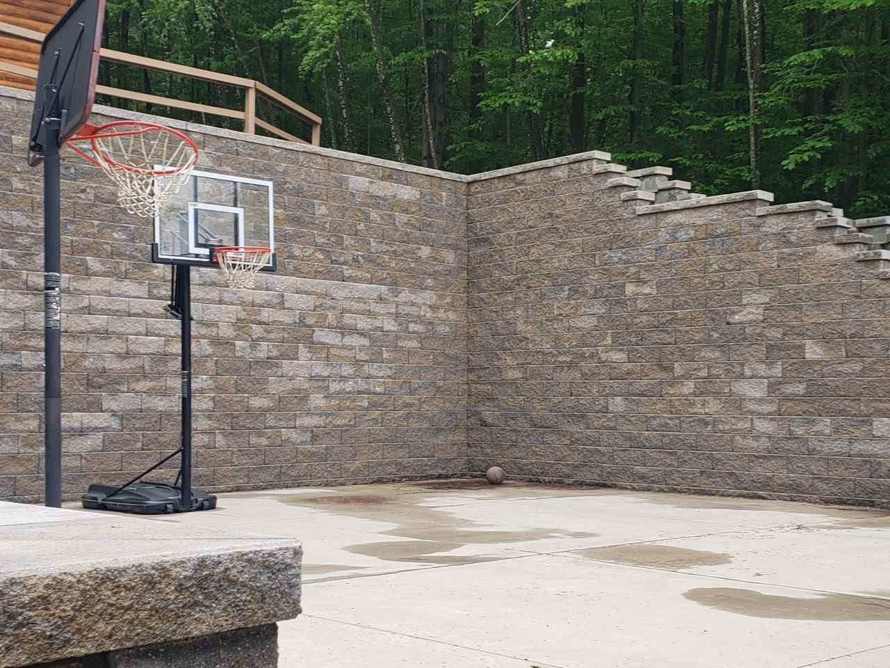 Retaining wall enclosing a backyard basketball court