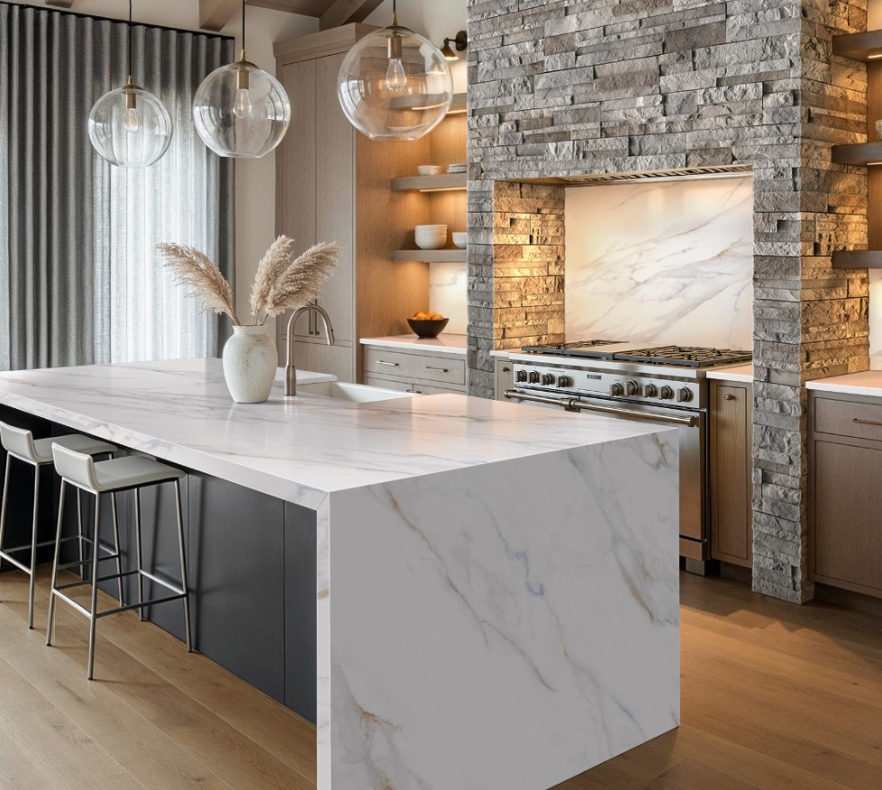 Kitchen with a stacked stone range surround and marble waterfall island