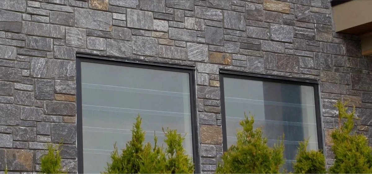 Home exterior wall in Pangaea ashlar natural stone around two windows